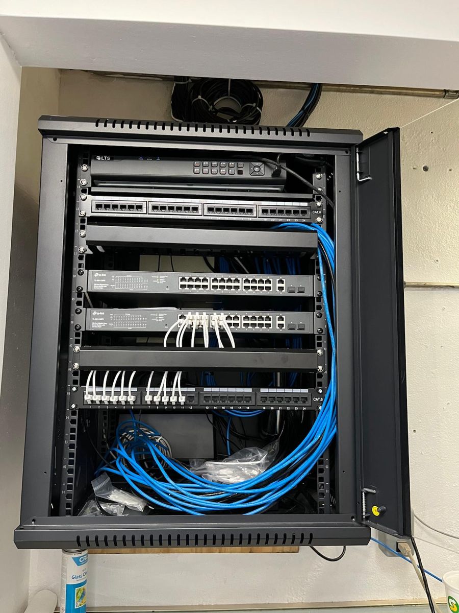 Wall-mounted rack with neatly routed blue patch cables